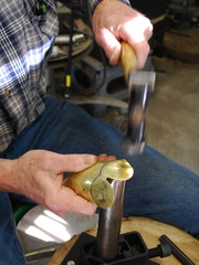 14. Using a flat topped stake to bend over the face elements.