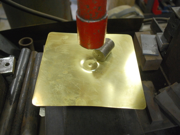 3. The bottom piece gets stamped with this special tool in the hydraulic press.