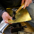 10. Now the edge of the top piece is bent over and hammered down tight against the bottom piece, using a tiny anvil.