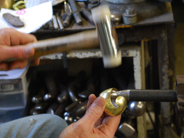 54. The piece of brass cut out, it's now being shaped on a ball stake.